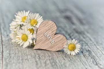 Obraz premium Valentines day red heart and flowers on old wood. Holidays card with copy space.