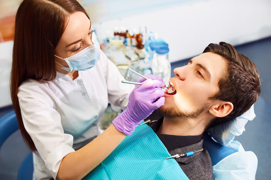 Overview of dental caries prevention. man at the dentist's chair during a dental procedure. Healthy Smile.

