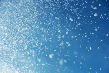 falling snow on blue sky
