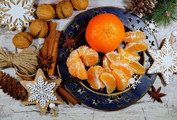 Juicy peeled tangerine on a plate on Christmas Eve
