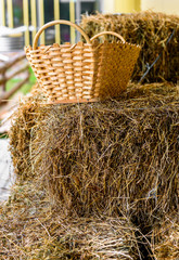 Basket on top of hay stack on a ranch.