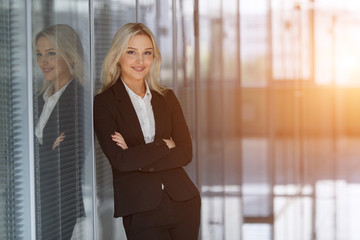 Beautiful businesswoman smiling with folded arms in office