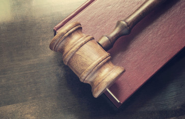 Gavel and legal book on wooden table