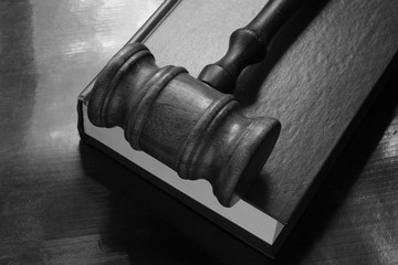 Gavel and legal book on wooden table