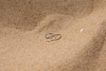 white gold wedding rings on the sand