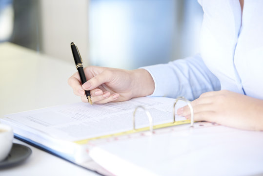 Fill the form. Close-up shot of a businesswoman using fountain pen while sitting at desk and fill the form.