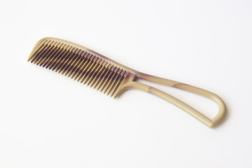 Brown plastic comb on white.
