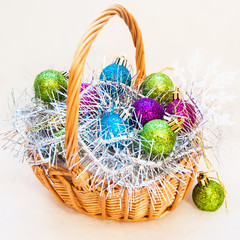 Christmas balls on tinsel in basket.  Photo in square format.