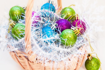 Christmas balls on tinsel in basket. Blurred photo for background
