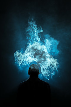 The man smoke a electronic cigarette on the dark background