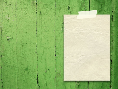 Single blank old paper frame on green wooden boards background