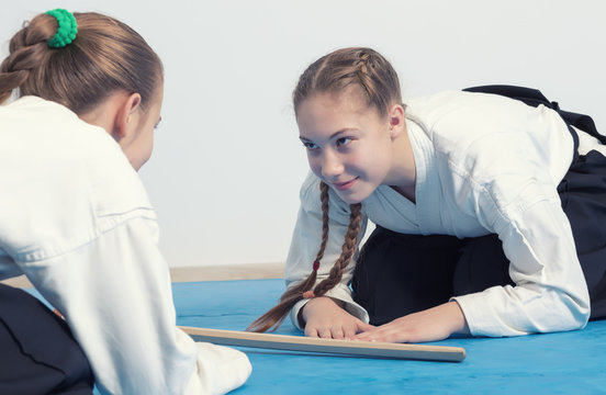Two girls in black hakama bow on Aikido training