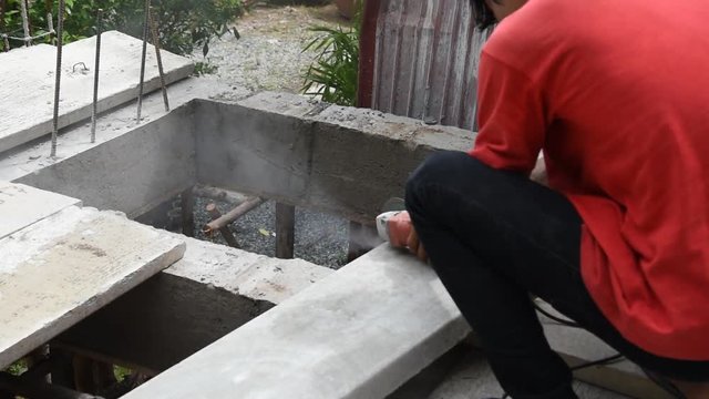 Worker cutting concrete slabs on the floor