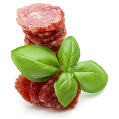 Salami smoked sausage slices and basil leaves isolated on white