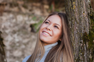 Beautiful woman next to the trunk of a tree