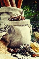 Christmas atmosphere: spices, candies, cones and nuts with fir p