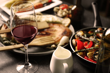 Glass of wine and grilled vegetables on served table