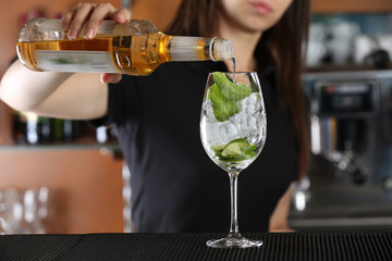 Woman hands making cocktail on bar counter