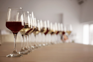 Glasses with red and white wine on table in restaurant