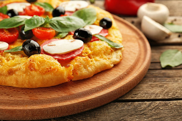 Delicious pizza with mushrooms, cherry tomatoes, olives and basil, closeup