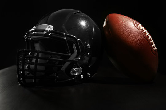 Rugby ball and helmet on dark background