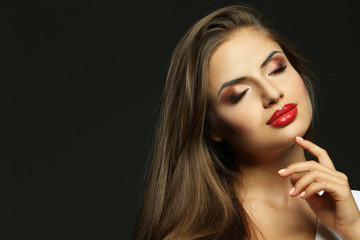 Portrait of beautiful young woman with professional makeup on dark background