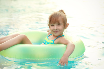 Fototapeta na wymiar Little girl in swimming pool on sunny day