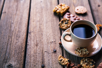 Obraz na płótnie Canvas cup of coffee with a delicious chocolate and cookies on a wooden background