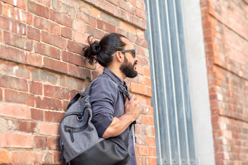 Fototapeta na wymiar man with backpack standing at city street wall