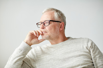 Obraz premium close up of senior man in glasses thinking