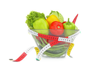 Fresh salad and measuring tape on white background
