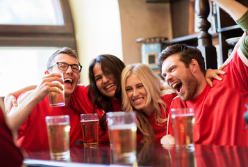 football fans or friends with beer at sport bar