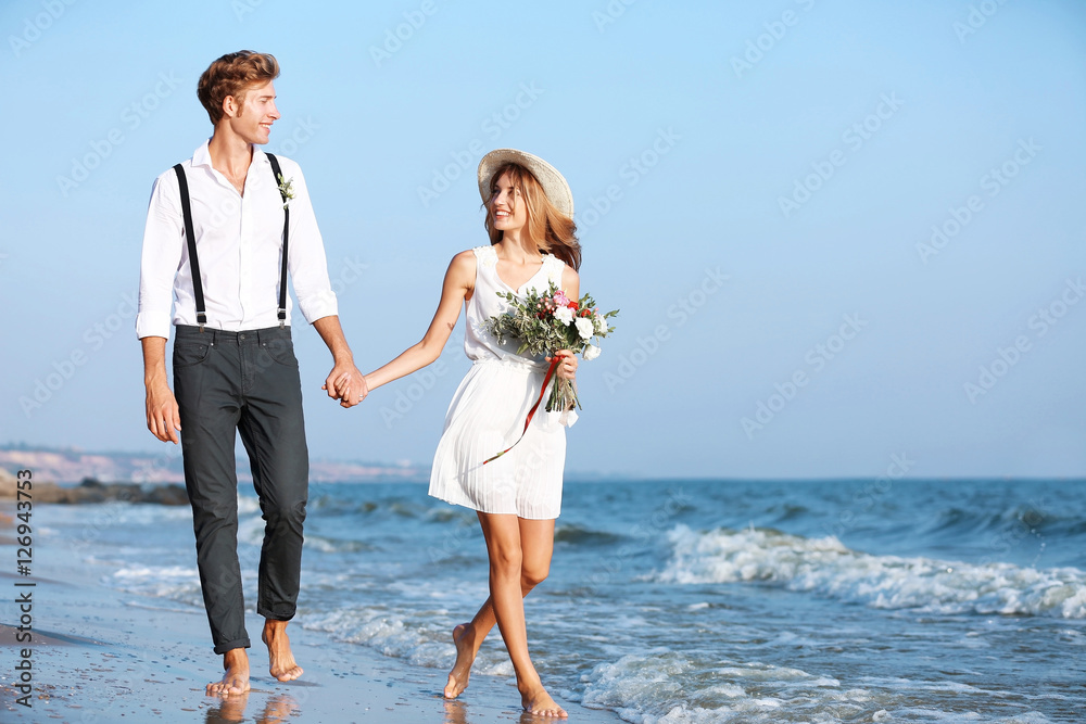 Sticker young happy couple walking on seashore