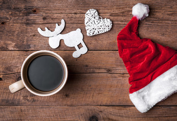 Obraz na płótnie Canvas Cup of coffee and Santas hat, Christmas set, gift and Christmas tree. Celebration