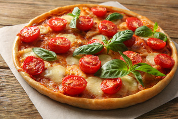 Fresh tasty pizza Margarita on baking paper, closeup