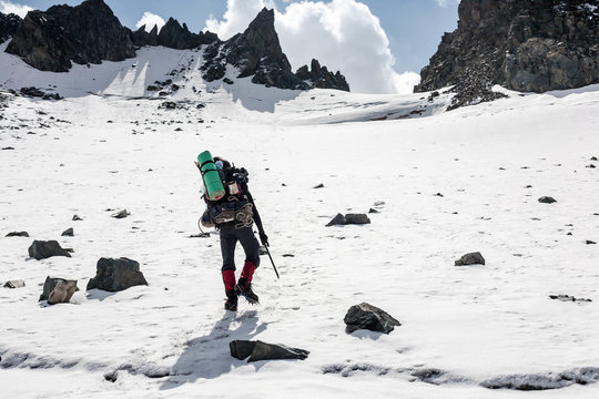 Hiker moving on land full of ice and snow at Tien Shan mountains