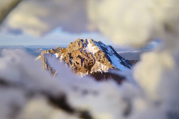 Rocky hill covered by snow in last evening light during wonderful calm winter sunset