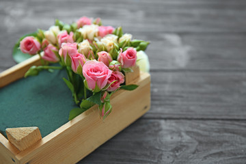 Naklejka na ściany i meble Beautiful flower composition in box on wooden background