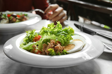 Tasty salad in white plate on table