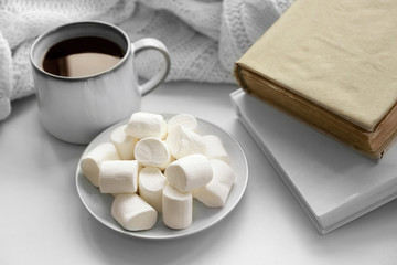 Fototapeta na wymiar Hot drink with books and marshmallows on windowsill