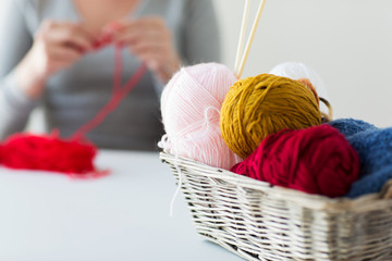 woman, basket with knitting needles and yarn balls