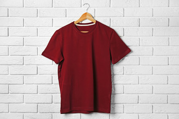 Blank maroon t-shirt against brick wall