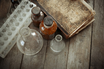 Fototapeta na wymiar Vintage equipment of chemical laboratory on wooden background, closeup