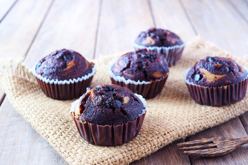 Close up of chocolate cheese cupcakes on a wooden table. Selective focus.