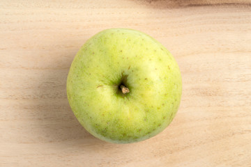 Top view of a green apple on wood background