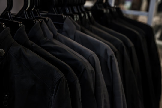Black shirt hanging on a rack in the store. Fashion and garment