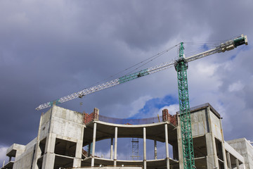 industrial construction crane on building site over dramatic sky