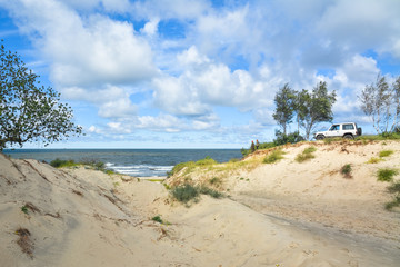 Two autotravellers at the seashore looking into the distance