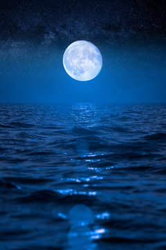 Full moon rising over empty ocean at night