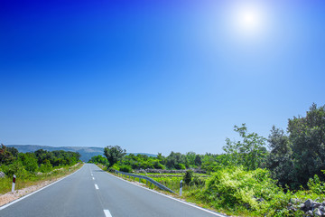 Beautiful asphalt freeway, motorway, highway without traffic through of southern landscape mountains forest during summer on a sunny day. Travel road concept.